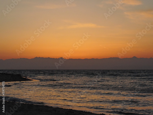 Sunrise from behind mountains by the beach