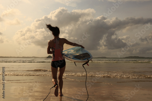 Young woman surfer wit surfboard ready to surf