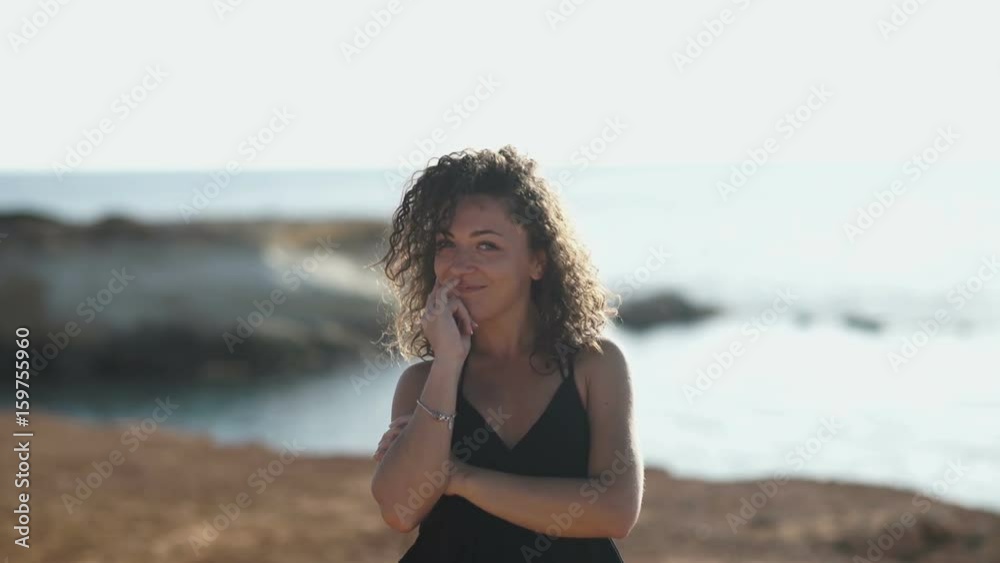 Beautiful portrait of curly girl at the background of the ocean Beautiful portrait of curly girl at the background of the ocean