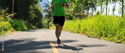 healthy lifestyle woman running at morning tropical forest trail