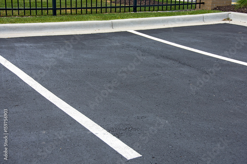 Slika na platnu vacant parking space with white lines on asphalt and curb