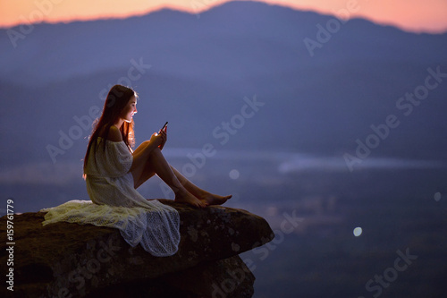 Beautiful Woman are using smartphone on after sunset