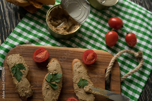 Liver pate on the bread on wooden tray. photo