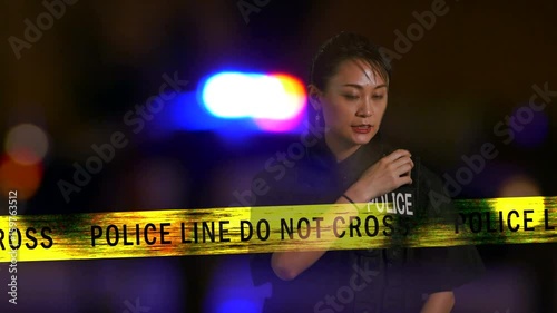 Asian American  female police officer calling in on radio from crime scene, Multiple exposure