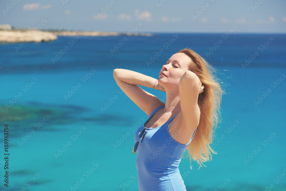 Beautiful young woman is relaxing on the beautiful rocky coast. Beautiful young woman is relaxing on the beautiful rocky coast.