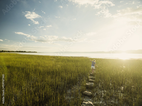 Small girl (4-5) walking on stepping stones in meadow photo