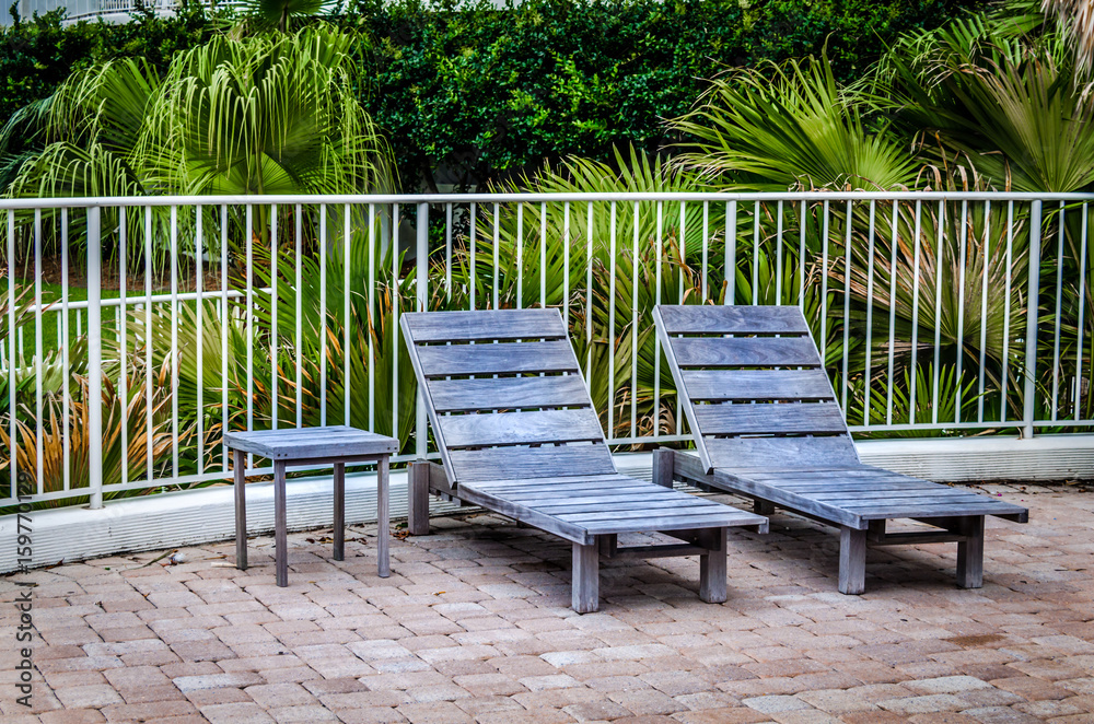 Rustic wooden deck chairs in tropical setting. Relax in this outdoor setting surround by tropical foliage. Rustic wooden deck chairs in tropical setting. Relax in this outdoor setting surround by tropical foliage.