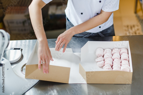 Woman wraps marshmallows in a cardboard box