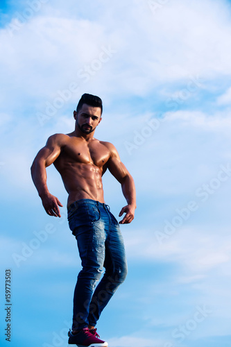 guy with muscular body on blue sky