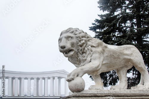 A monument of a lion with a ball