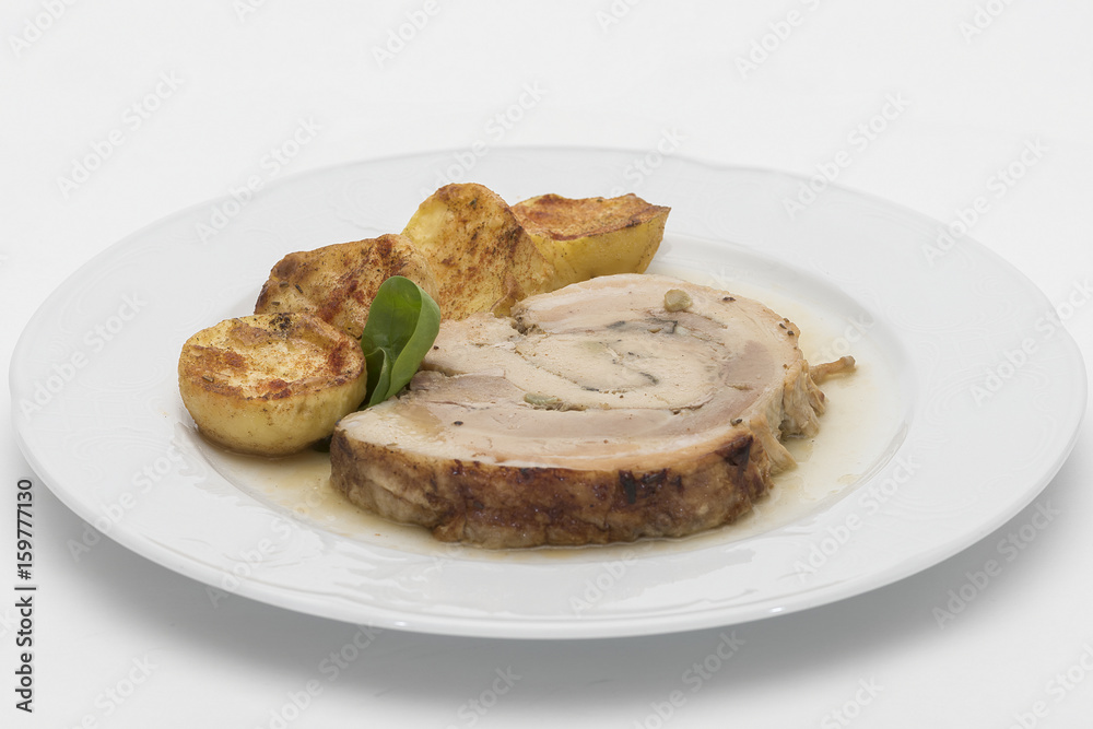 Slice roasted pork, served with potatoes and decorated with herbs, placed on white plate, light background, isolated