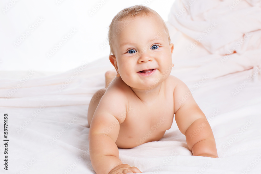 Cute smiling baby lying on towel isolated on white Cute smiling baby lying on towel isolated on white