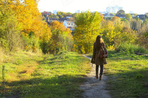 Attractive young woman walking in the forest. Young woman walking over autumn background.Shot of an attractive young woman in the park on an autumn day. 