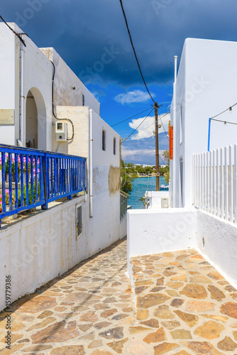 Narrow street and white houses and blue sea in background in Pollonia, Milos Island. Cyclades. Greece. © vivoo