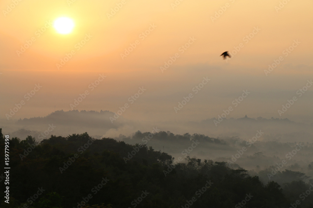 Sunrise view of Borobudur temple in the background. Misty rainforest in Java, Indonesia, Southeast Asia. Sunrise view of Borobudur temple in the background. Misty rainforest in Java, Indonesia, Southeast Asia.