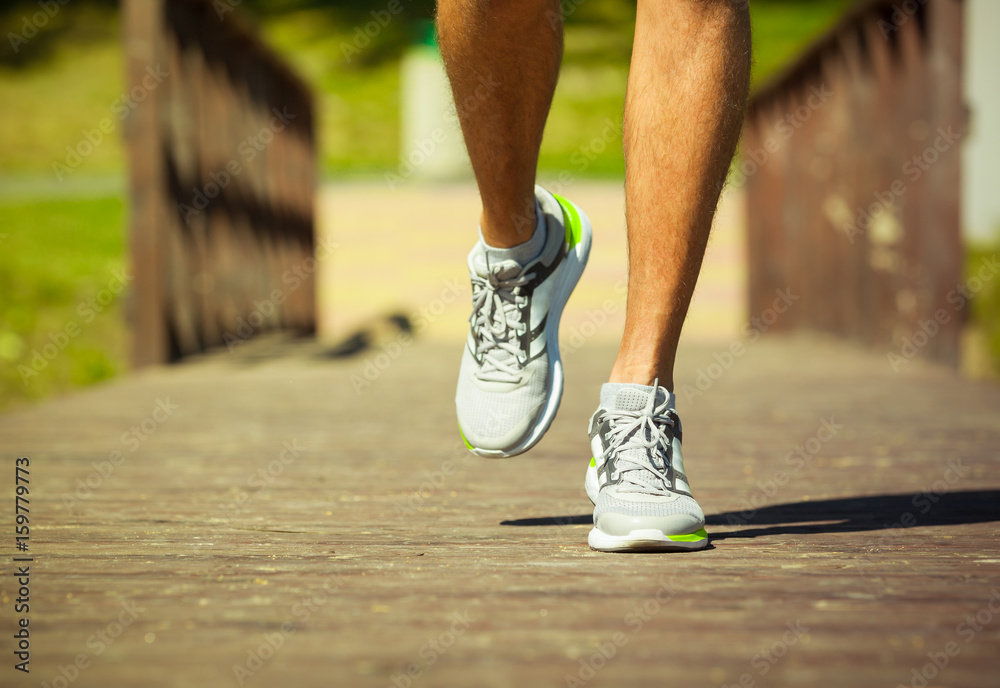 Closeup of male runner's feet running on wooden bridge. Closeup of male runner's feet running on wooden bridge.