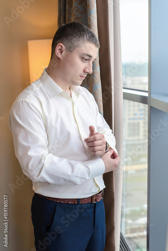 Free Download Young man buttoning cuffs on the sleeves of the shirt - GFXLoad