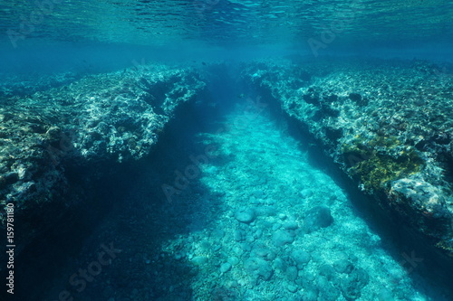 Rocky underwater seascape, trench in the outer reef eroded by the waves, Pacific ocean , Huahine, French Polynesia, Oceania