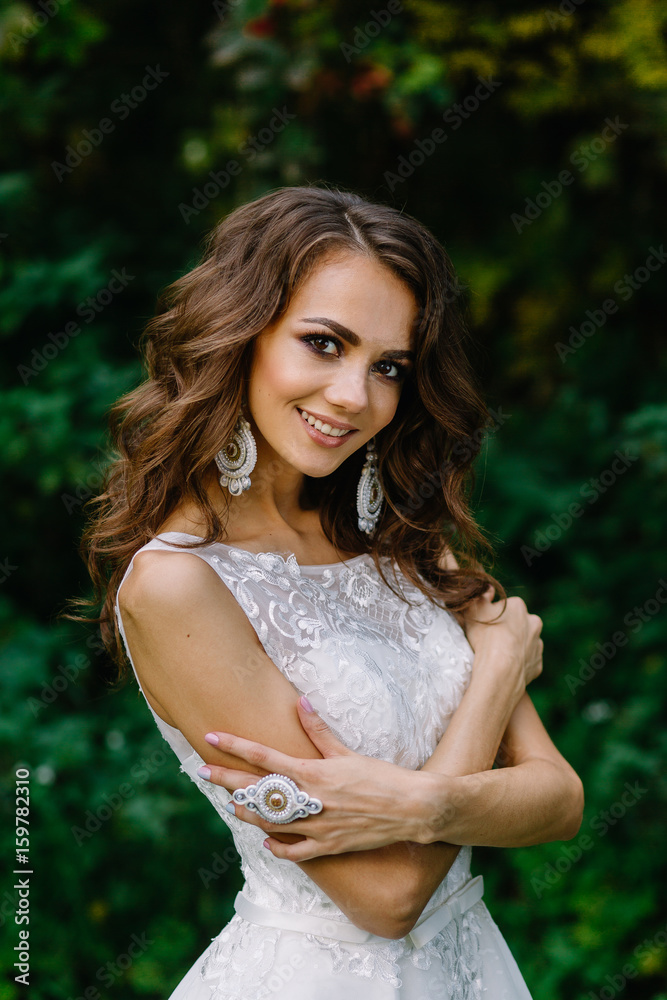 Very beautiful bride in chic wedding dress. Expensive beautiful accessories. Make-up of the bride. Portrait of a young girl on wedding day. Photoshoot in a beautiful place and picturesque background. Very beautiful bride in chic wedding dress. Expensive beautiful accessories. Make-up of the bride. Portrait of a young girl on wedding day. Photoshoot in a beautiful place and picturesque background.