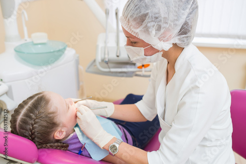 Young girl on a dental exam with female dentists