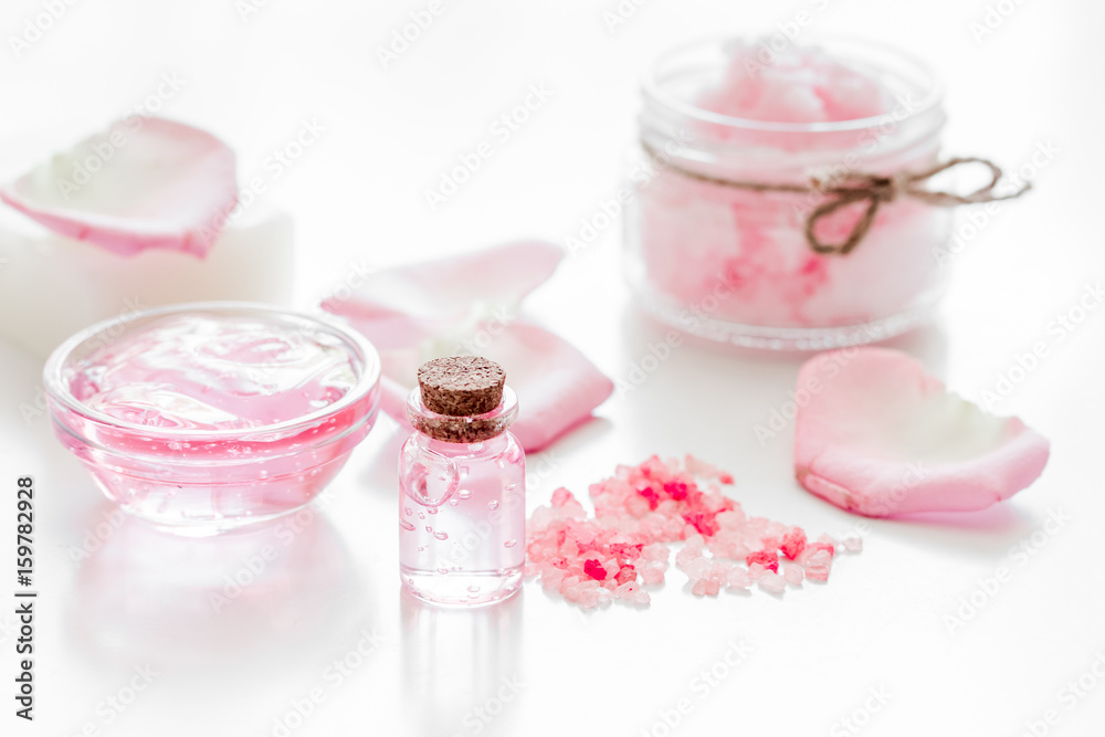 spa set with rose flowers extract and cosmetic for body on white desk background spa set with rose flowers extract and cosmetic for body on white desk background