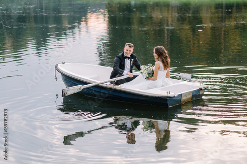 The groom skates the bride on a boat. Loving couple on a walk after the ceremony