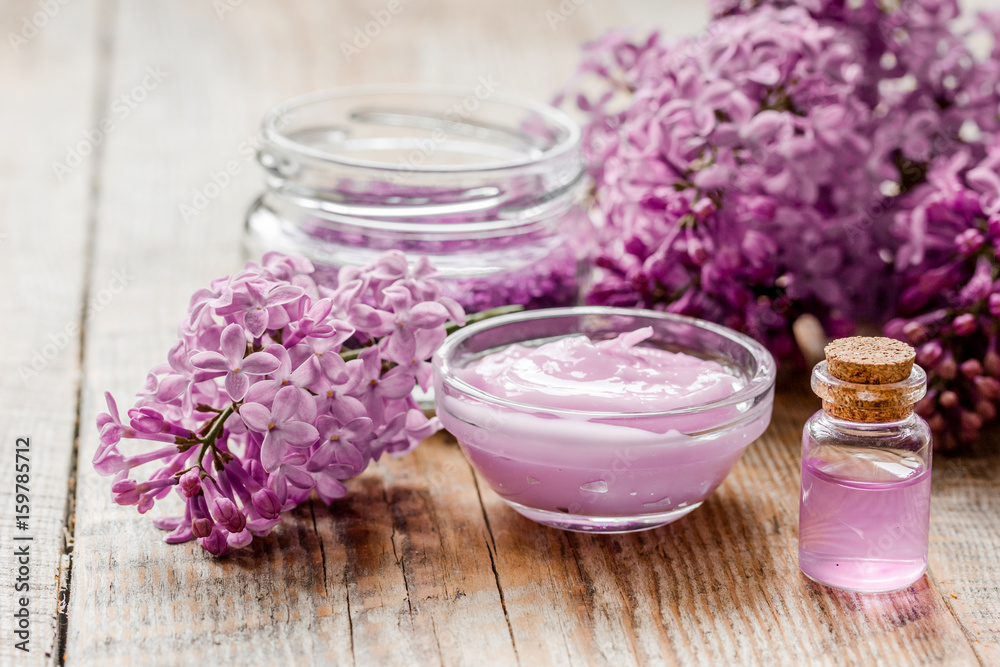 take bath with lilac cosmetic set and blossom on wooden table background take bath with lilac cosmetic set and blossom on wooden table background