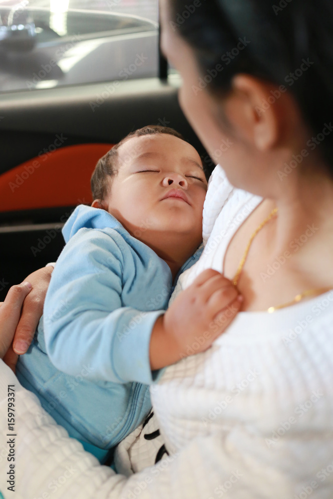 Asian boy is sleeping in his mother's arms. Asian boy is sleeping in his mother's arms.