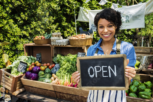 Greengrocer selling organic fresh agricultural product at farmer market photo