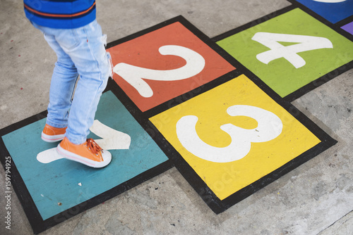 Young kid playing hopscotch photo
