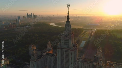 Flying over Moscow state university and Moscow city business center at sunny sunrise. City in fog. Russia. Aerial View.