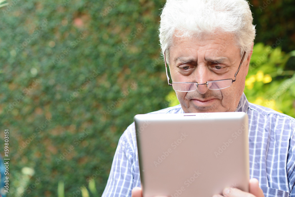 Old man using digital tablet. Old man using digital tablet.