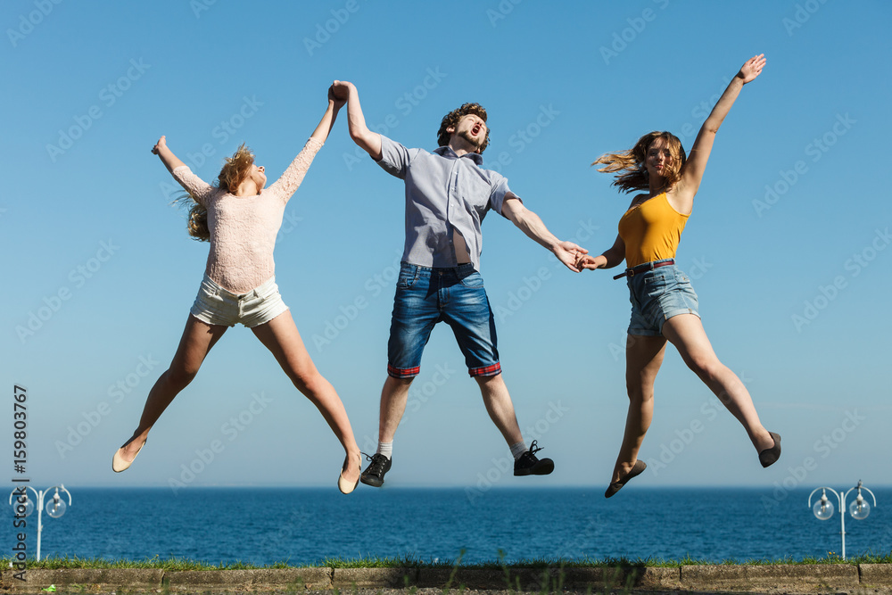 Carefree friends jumping by sea ocean water. Carefree friends jumping by sea ocean water.