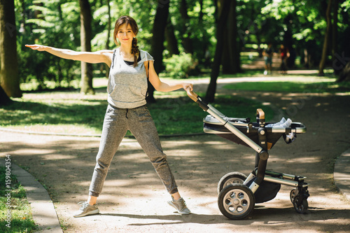 Series photo of happy sporty mother with baby pram workout and warming up bebore jogging in summer park. Full height photo