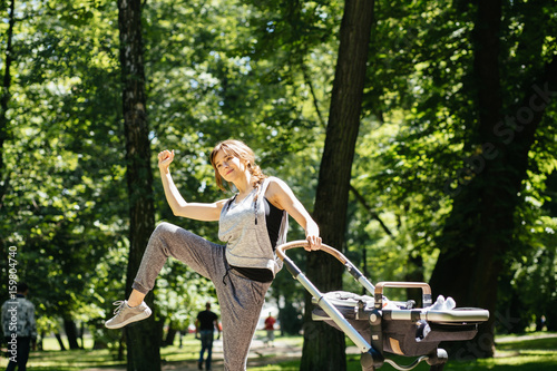 Series photo of happy sporty mother with baby pram workout and warming up bebore jogging in summer park. photo