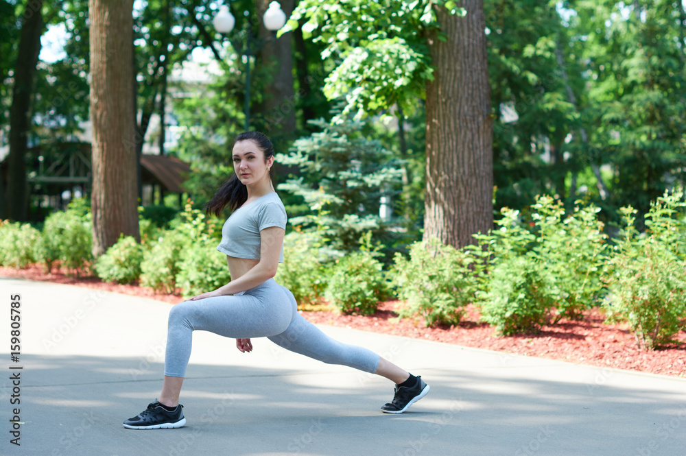 Beautiful brunette girl exercising in a green park. Training in nature. A healthy lifestyle. Sportswear. Happy girl. Beautiful brunette girl exercising in a green park. Training in nature. A healthy lifestyle. Sportswear. Happy girl.