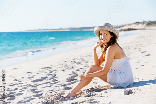 Wallpaper Mural Young woman sitting on the beach Torontodigital.ca