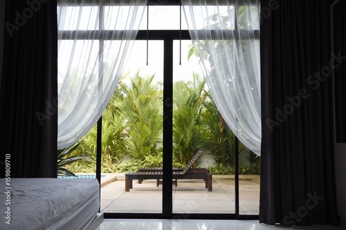 View of garden through windows with blinds.