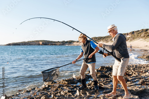 Senior man fishing with his grandson