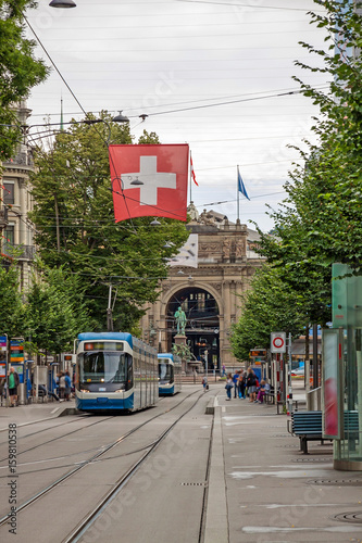 Zurich shopping street Bahnhofstrasse with tram and swiss flag