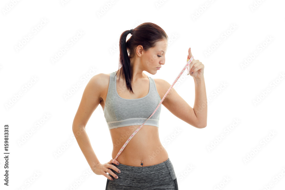 Slim girl takes fitness a waist measuring tape Slim girl takes fitness a waist measuring tape