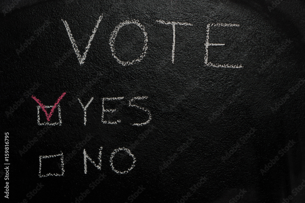 Fototapeta premium Yes or No vote written with white chalk on blackboard
