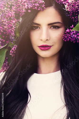 Beautiful Woman with Lilac Flowers Outdoors. Beauty Fashion Portrait