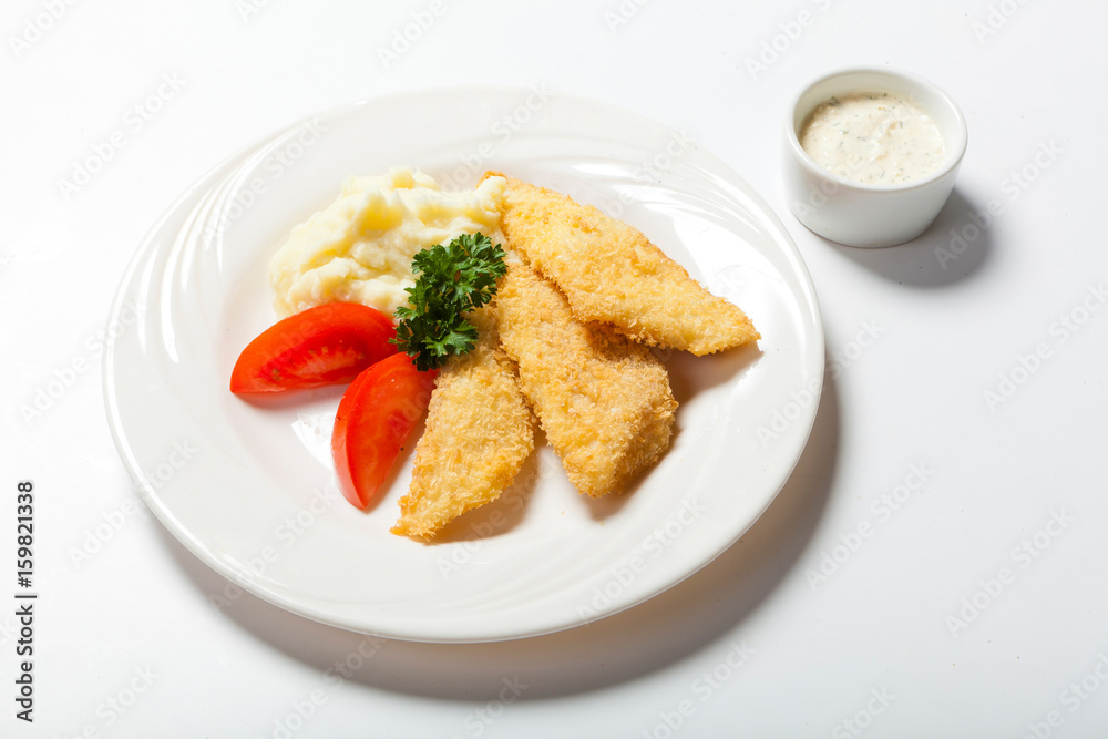 fish in breadcrumbs with garlic sauce on the white background