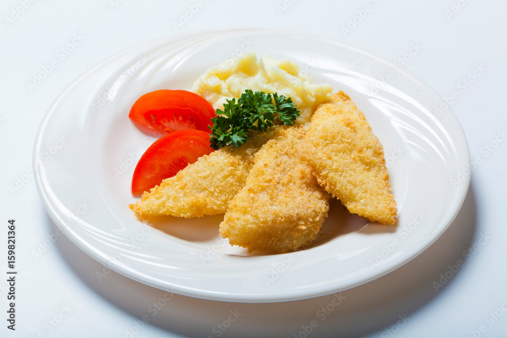 fish in breadcrumbs with garlic sauce on the white background fish in breadcrumbs with garlic sauce on the white background