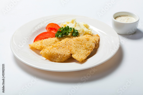 fish in breadcrumbs with garlic sauce on the white background