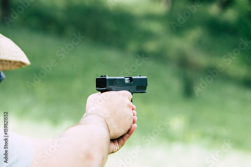 A gun in his hand. Training. Shooting at targets