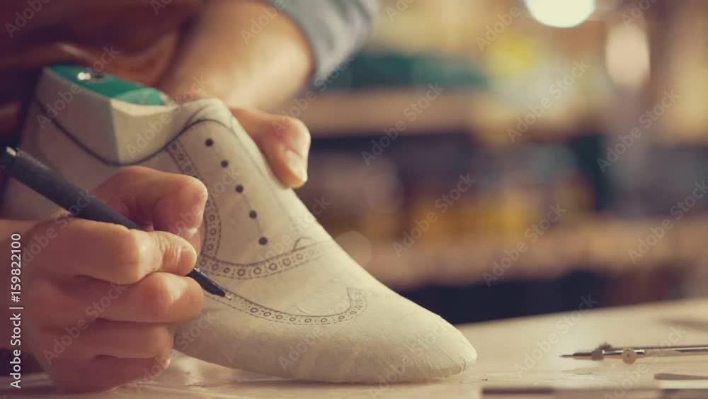 Cropped video of young shoemaker sitting in workshop making shoes