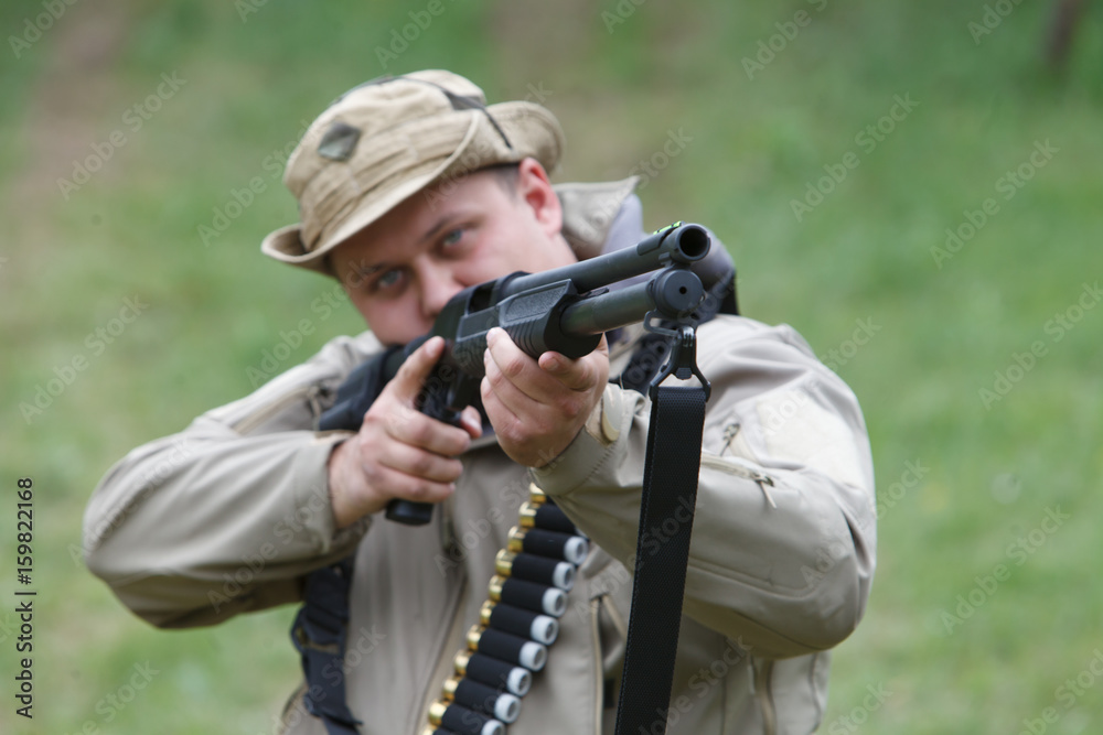 Hunter with a gun. Standing in the forest and waiting for prey