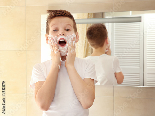 Cute boy with shaving foam ...